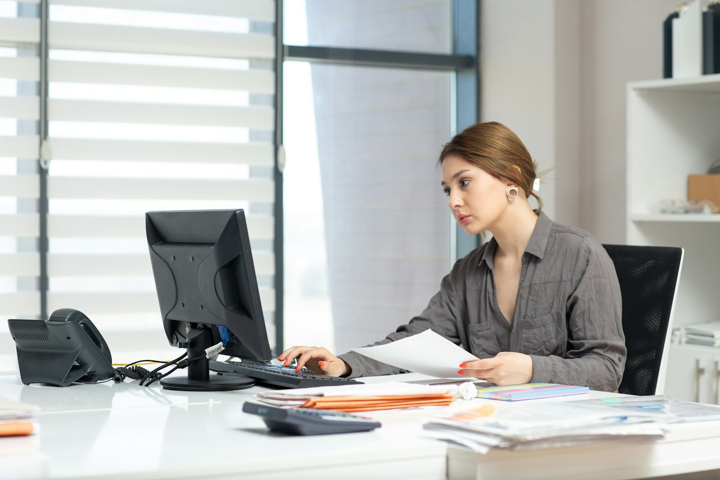 Administrator working through documents at a computer