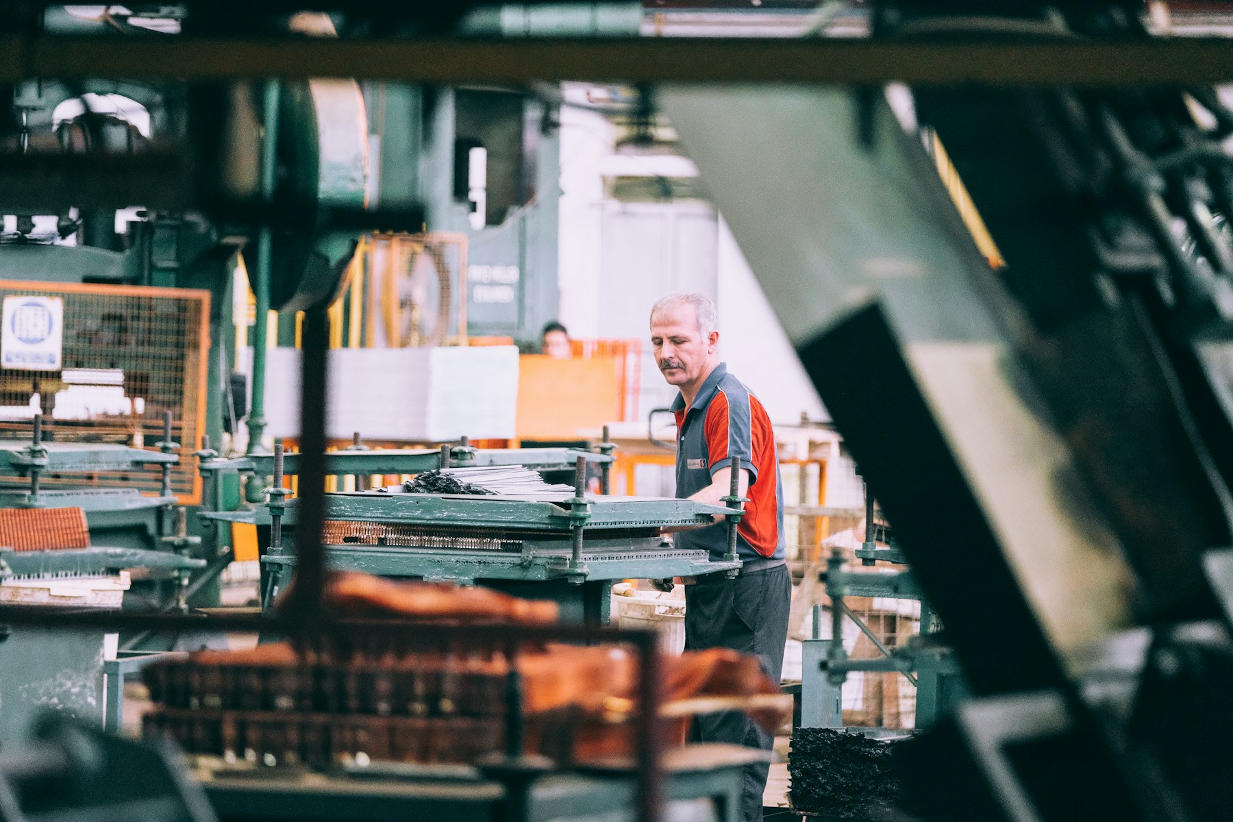 Operator running industrial machinery on a plant floor