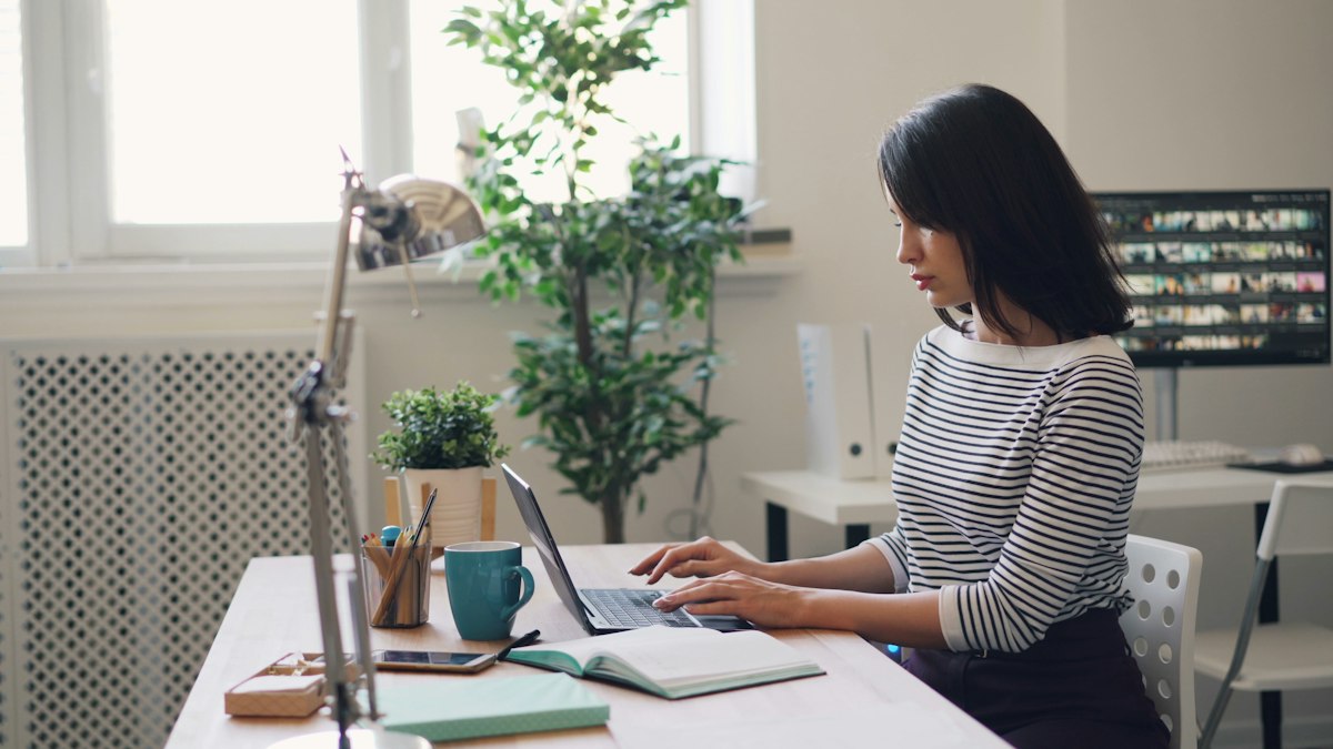 Administrative assistant working at a desk by a window
