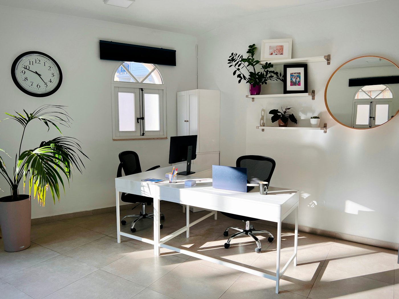 Bright office with a wall clock and plants